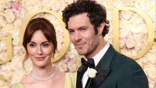 Leighton Meester wearing a lime green gown and Adam Brody wearing a green tux posing on Golden Globes 2025 red carpet