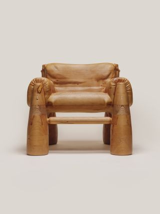 A chunky wooden chair features wood-made, faux upholstery and big slanted legs.