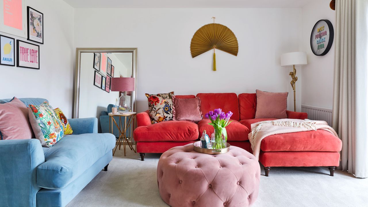 Colourful living room with red sofa, cushions, pink pouffe