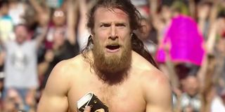 Daniel Bryan with long hair holding the WWE title after a ladder match.