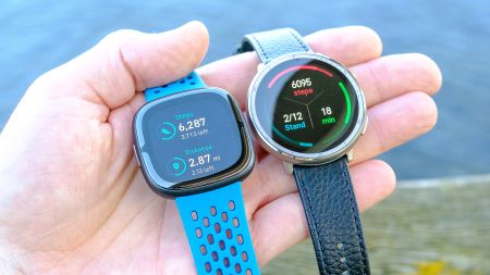 Close up of the Amazfit Active 2 smartwatch next to the Fitbit Sense 2 with each showing the total step count for the day