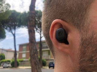 En man ute på promenad med ett par Skullcandy Grind True Wireless Earbuds i öronen