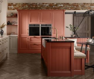 shaker kitchen with coral and stone colored units and parquet wood floor