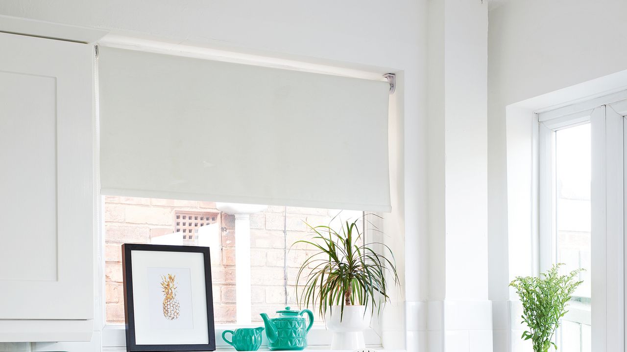 White kitchen with white roller blinds