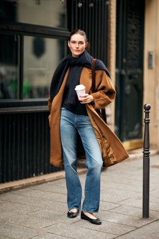 woman wearing sweater, coat, jeans, and ballet flats