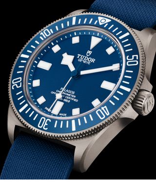 Close up image of the Tudor Pelagos FXD watch, blue, white and silver face, blue strap, black background