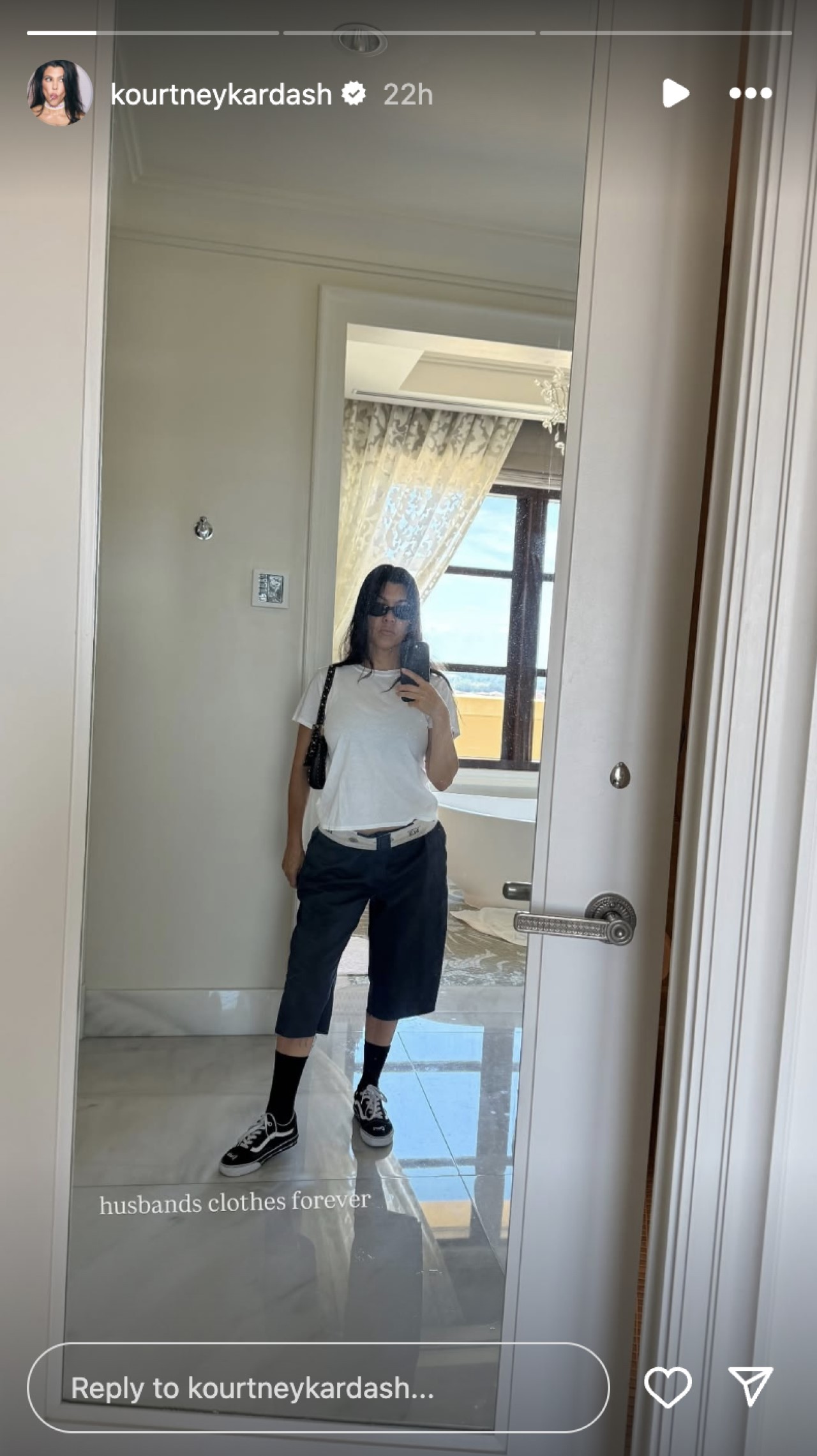 Kourtney Kardashian takes a mirror selfie wearing Travis Barker&#039;s clothes.