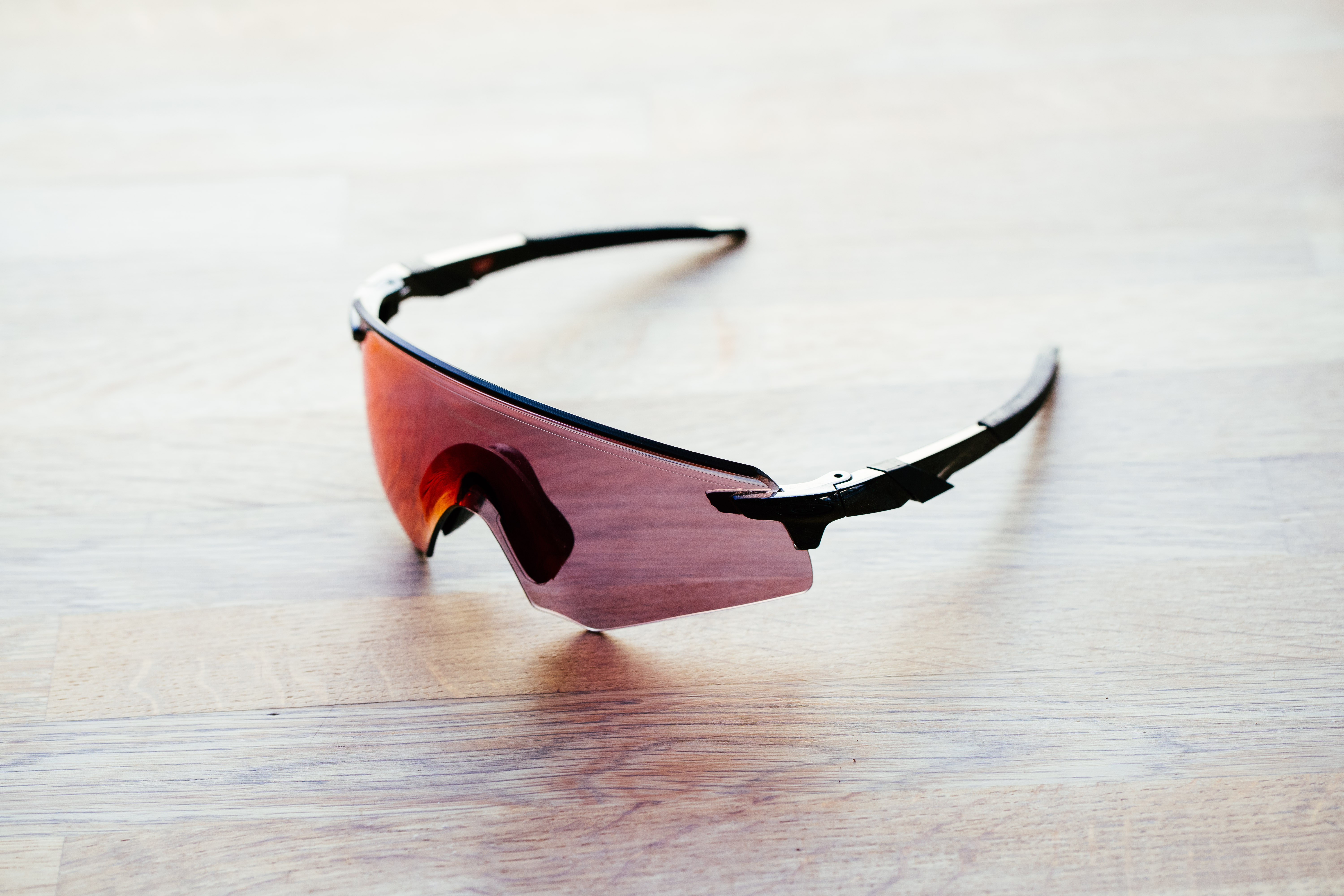 A set of frameless cycling glasses on a wooden surface