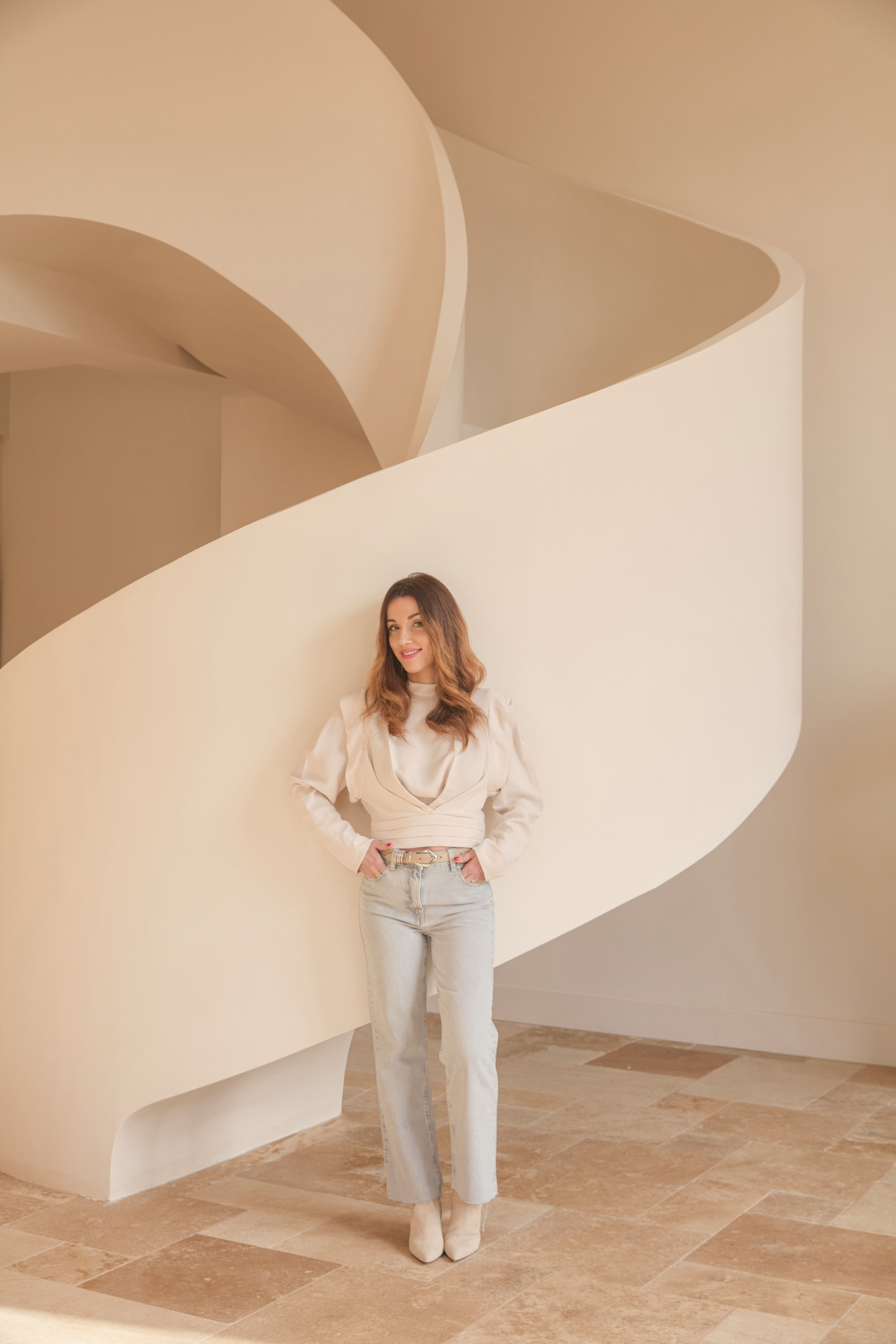 Interior designer H&amp;eacute;l&amp;eacute;na Monnet-Plat standing in front of a white spiral staircase