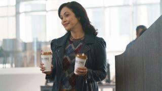 Baez holding two cups of coffee on Boston Blue.