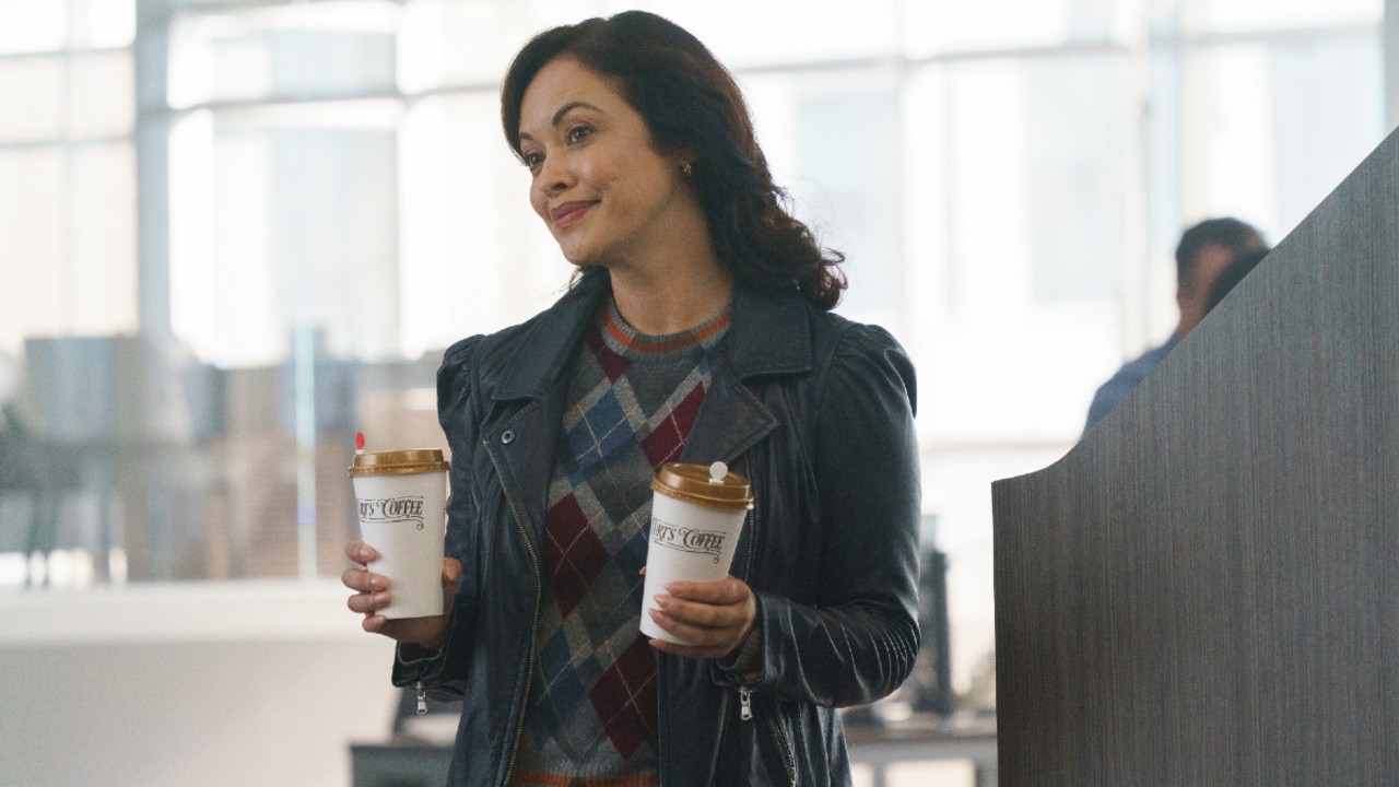 Baez holding two cups of coffee on Boston Blue.