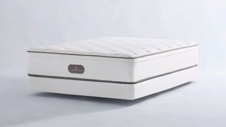The Four Seasons Hotel Signature Mattress on a box spring in a plain room