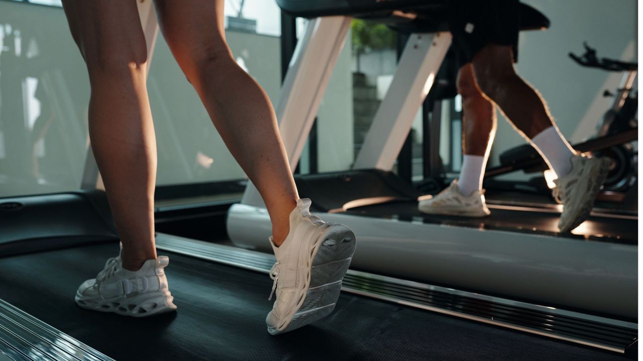 Woman's legs on treadmill doing indoor walking workouts