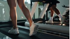 Woman's legs on treadmill doing indoor walking workouts