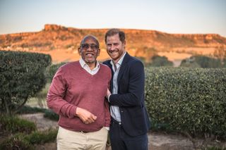 Prince Harry and Prince Seeiso of Lesotho hugging in front of a mountain