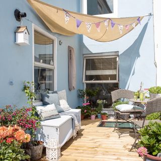 Courtyard garden surrounded by blue walls and covered with fabric canopy