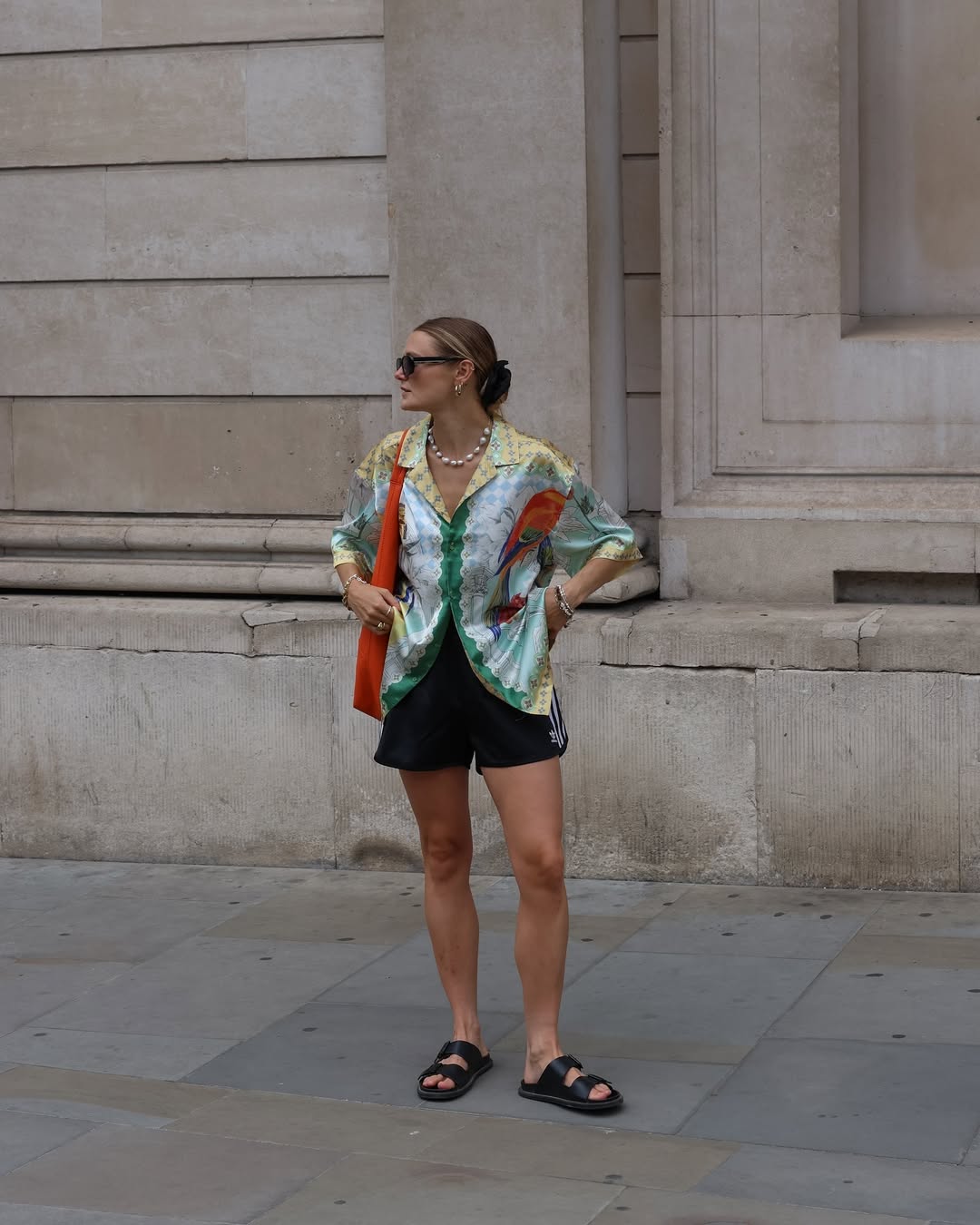 Millie Holmes in a silk top and sporty shorts