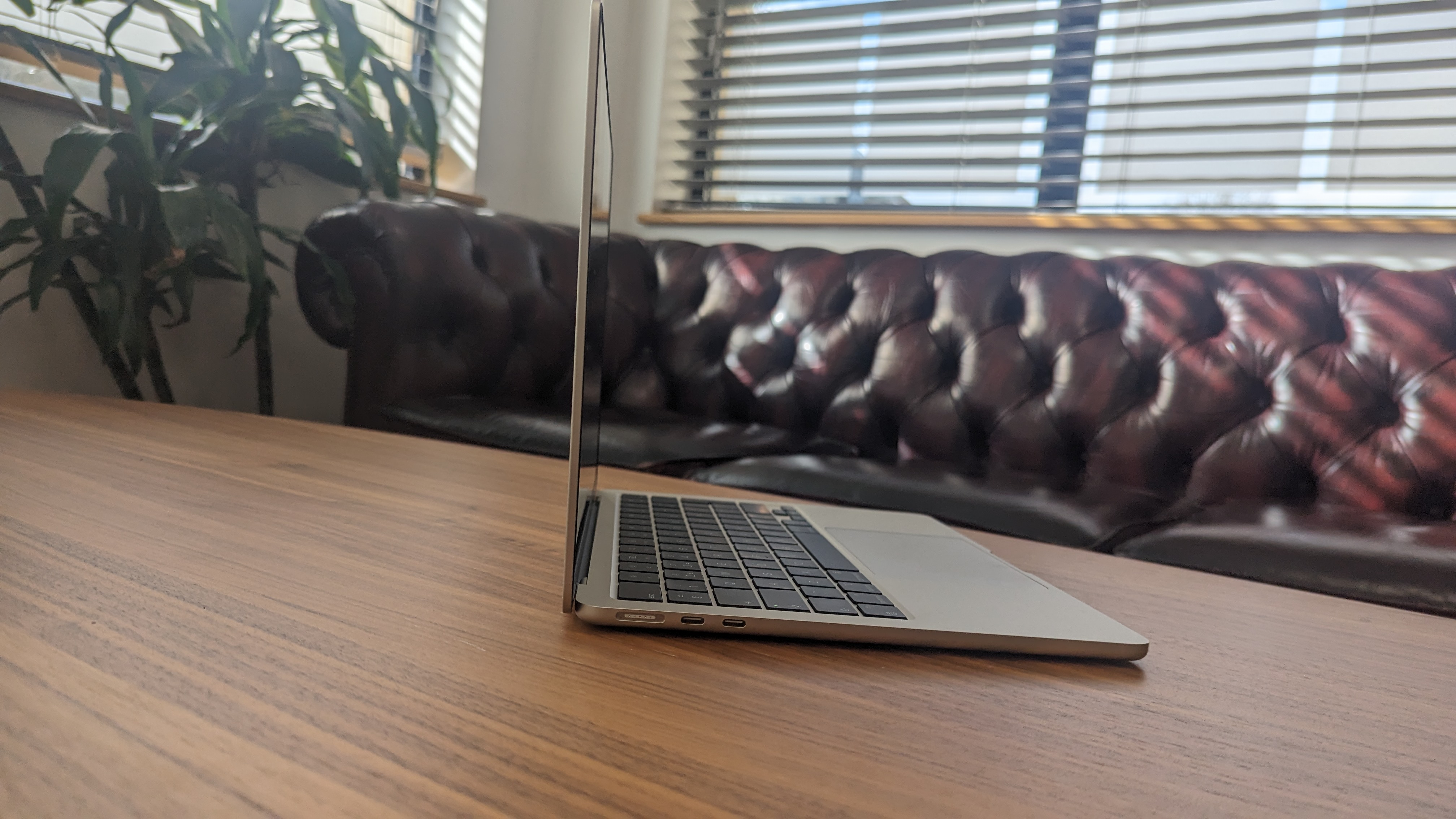 Nya MacBook Air står öppnad på ett cafébord, sedd från sidan.