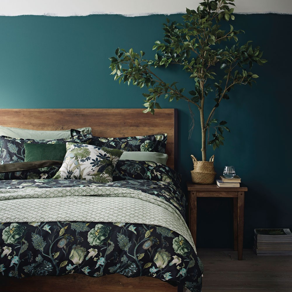 bedroom with hero floral print bedding set and plant
