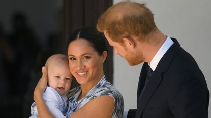 Meghan Markle holds son Prince Archie while Prince Harry looks on