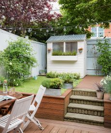 garden with shed potted plants and white chair