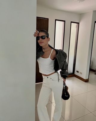 Jen Ceballos wearing white jeans and leather jacket.