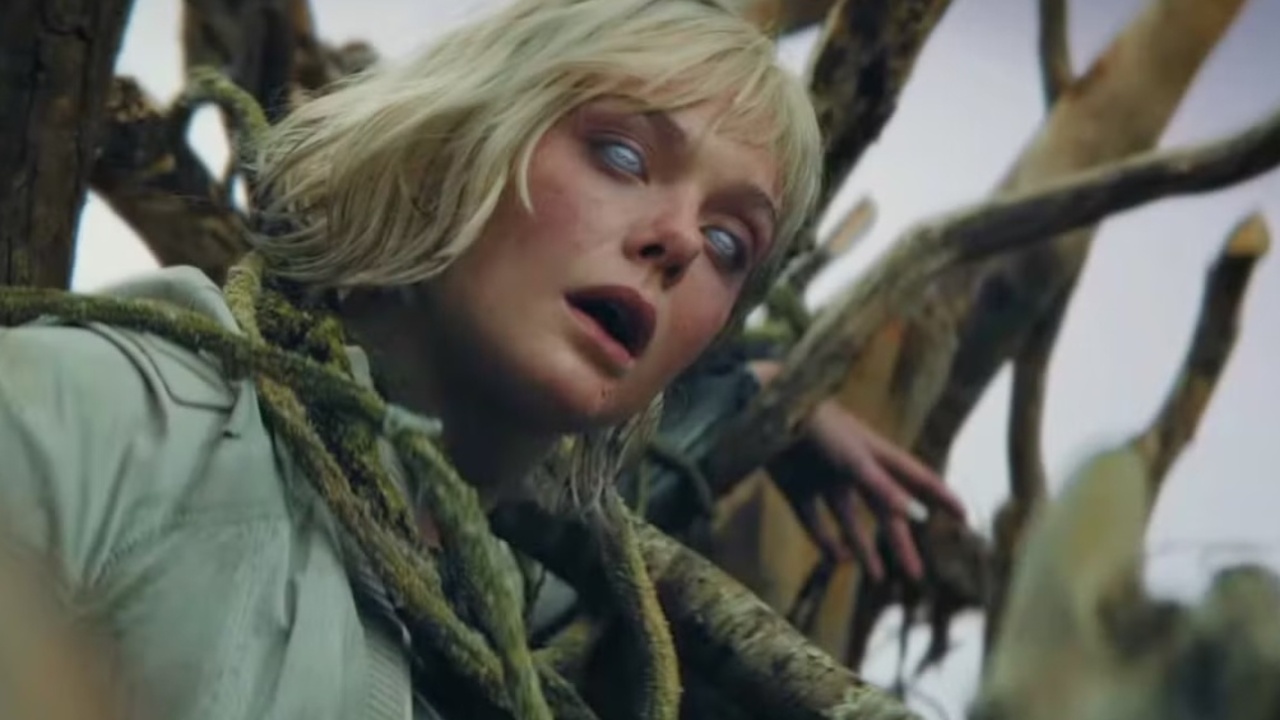 Screenshot from Predator Badlands showing a blonde female android hanging in some vines, with its eyes completely white.