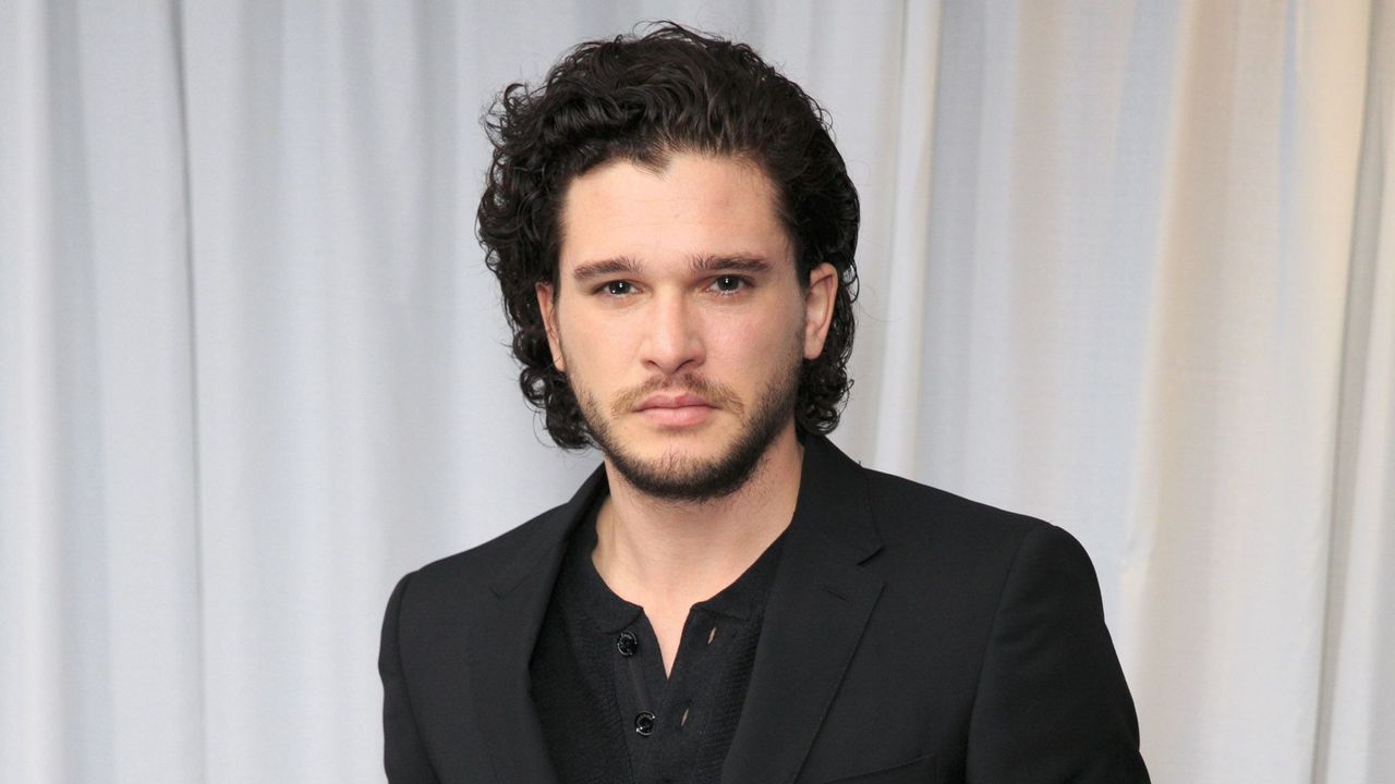 Kit Harrington in a black suit.