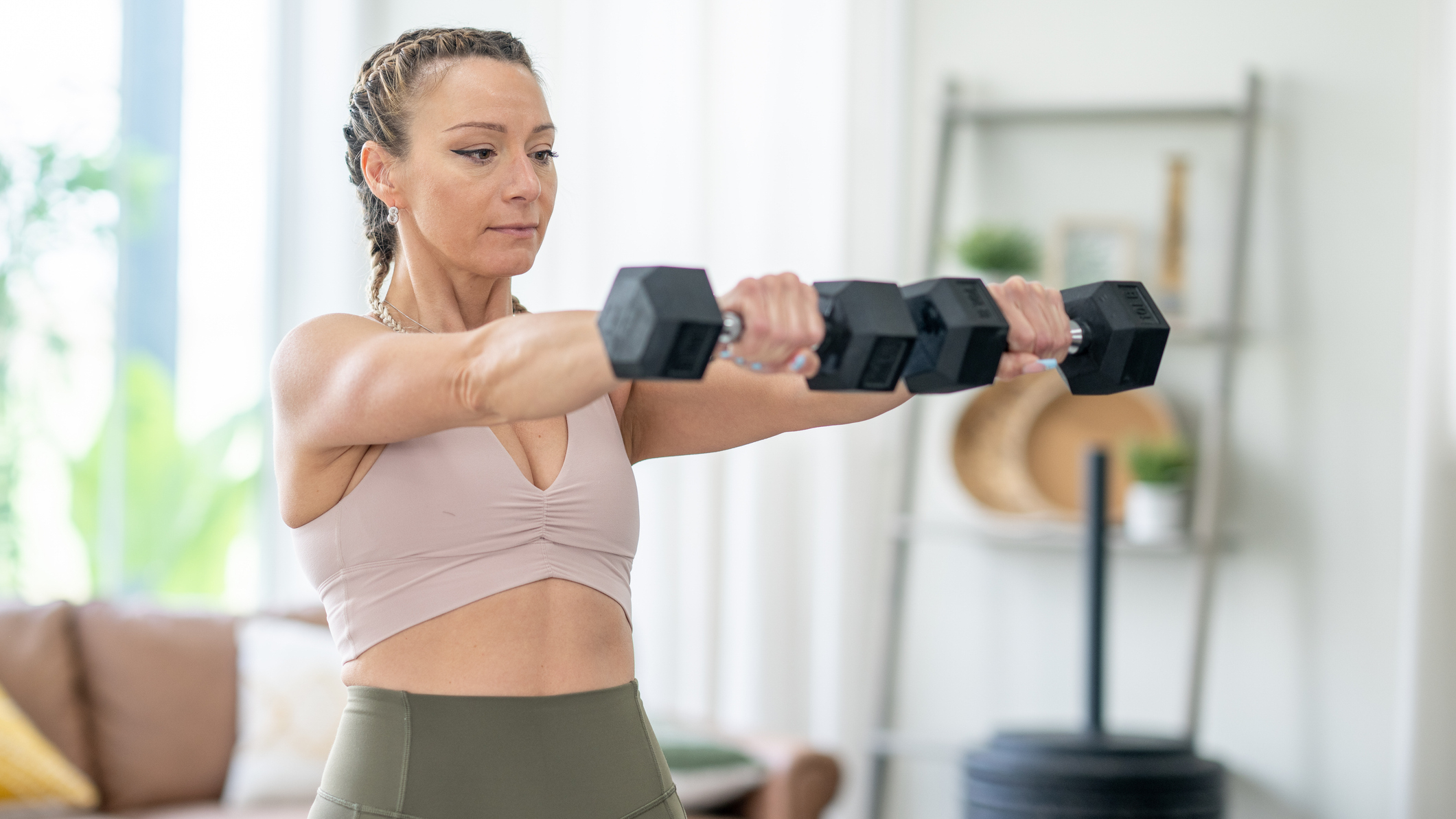 Woman exercising with dumbbells at home