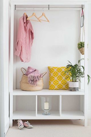 White hallway with storage unit with coats hanging showing how to organise a small hallway