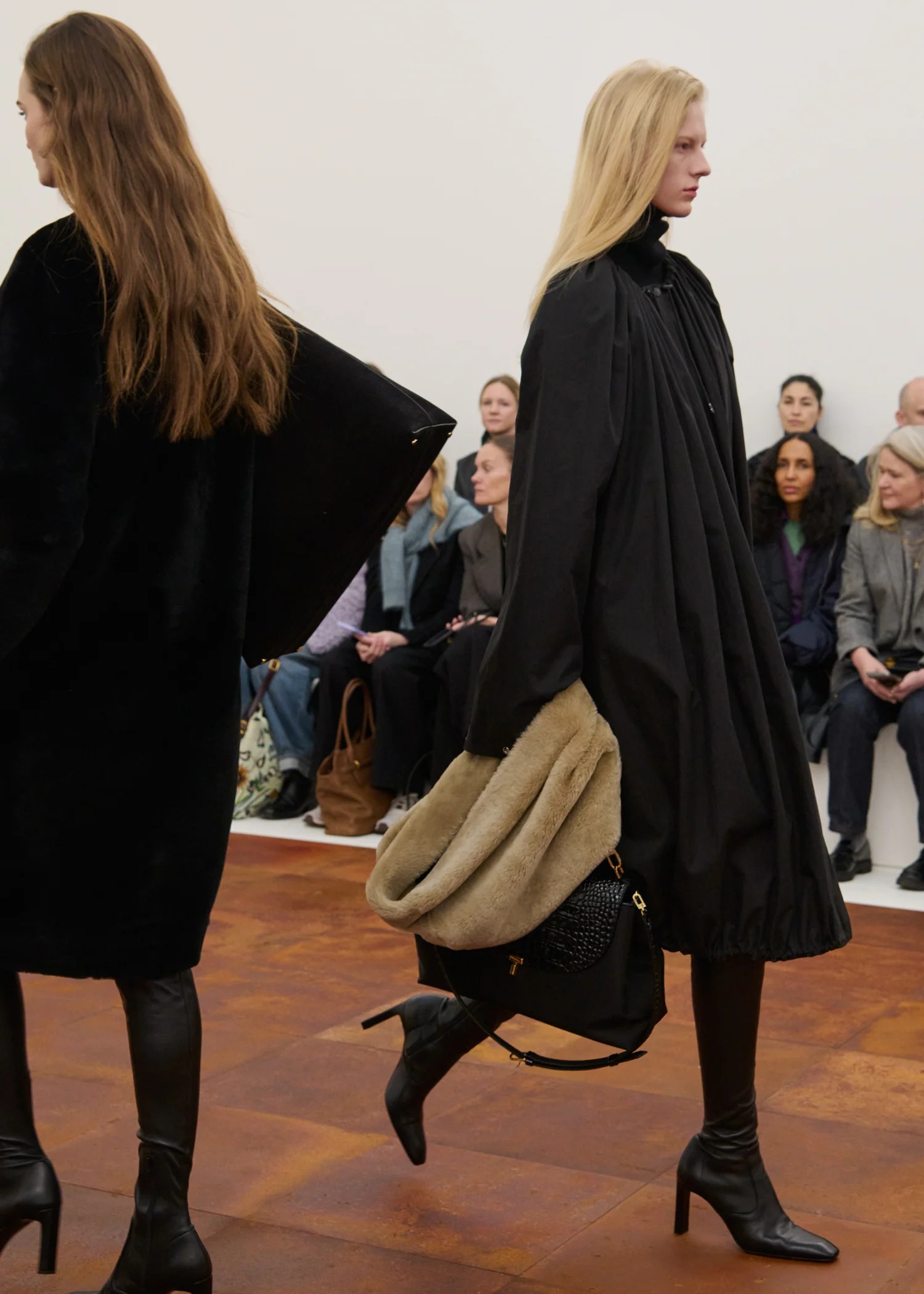 Woman in black coat and skintight boots.