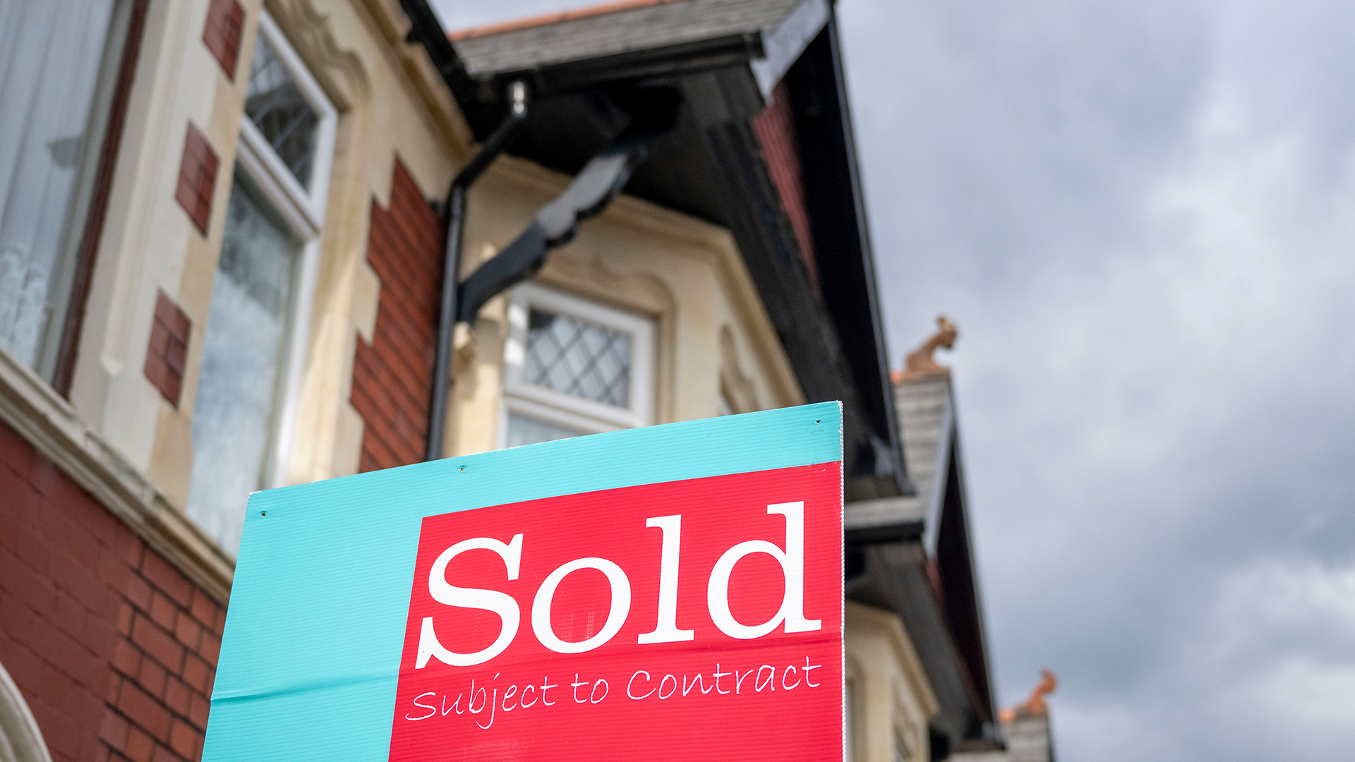 Red and blue Sold sign outside a period property