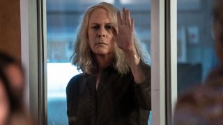 Jamie Lee Curtis in Halloween Kills with palm on glass wall