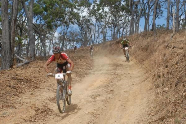 A racer speeds down a gravel road