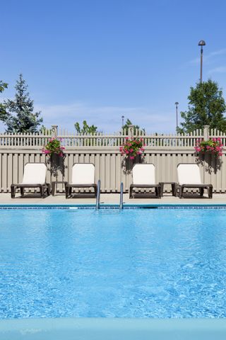 pool fence ideas: loungers next to a pool