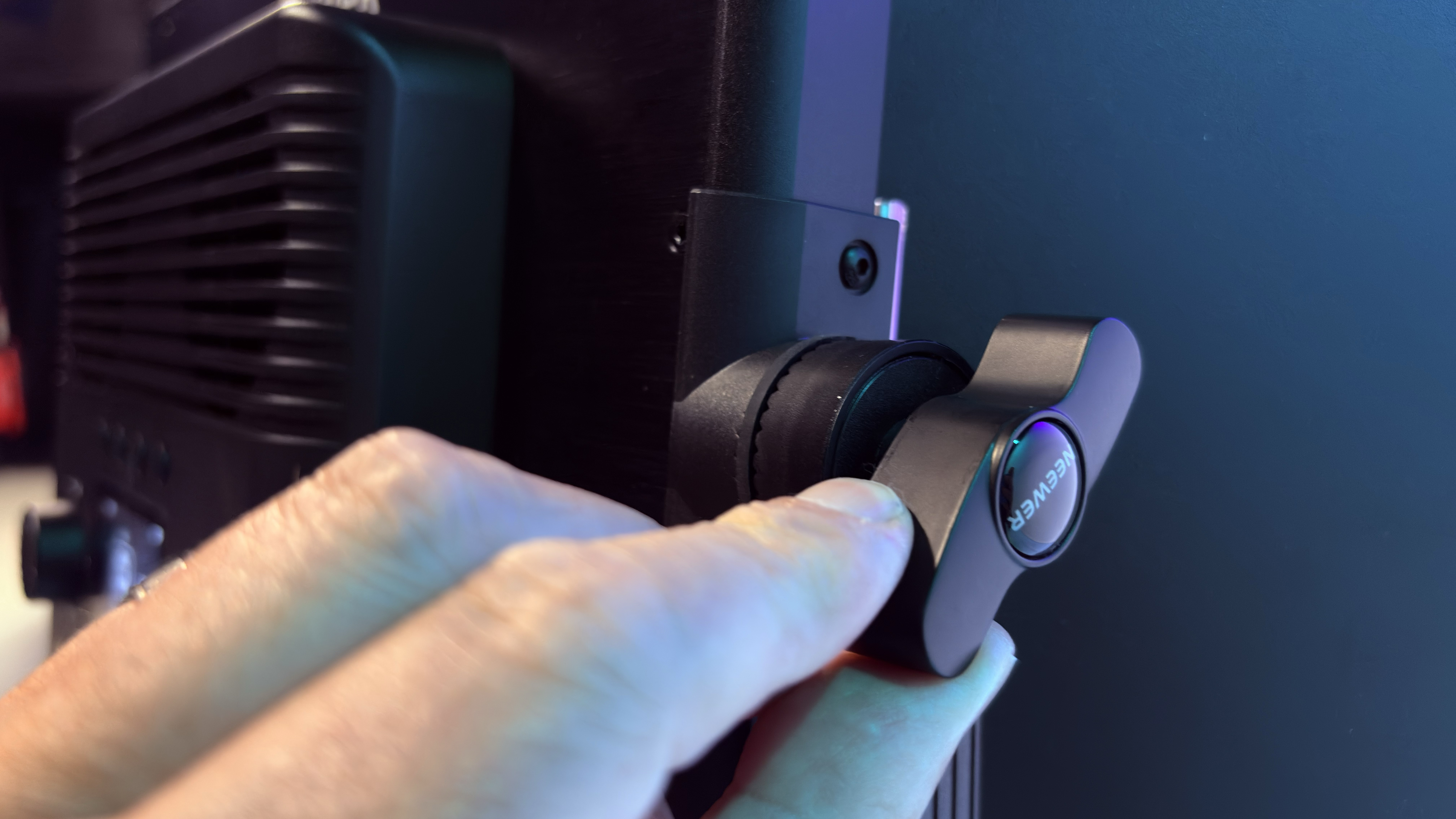 Close-up of a hand tightening the knob that enables the U-btacket to tilt up or down