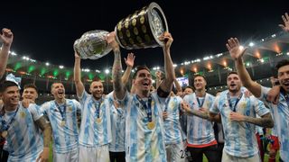 Lionel Messi and his team hold the Copa America Trophy aloft in celebration on the pitch