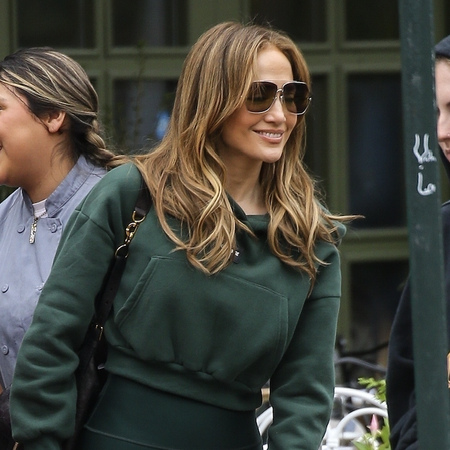 Jennifer Lopez was seen walking casually outside a caf&eacute; in New York City, dressed in a dark green cropped hoodie and high-waisted leggings. She accessorized with oversized sunglasses and a black crossbody bag, radiating effortless style and joy as she engaged with friends. Jlo was all smiles after recently performing at 2025 Saudi Arabian Formula 1 Grand Prix.