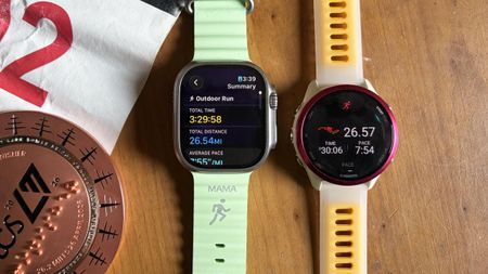 a photo of the Apple Watch Ultra 3 and Garmin Forerunner 570