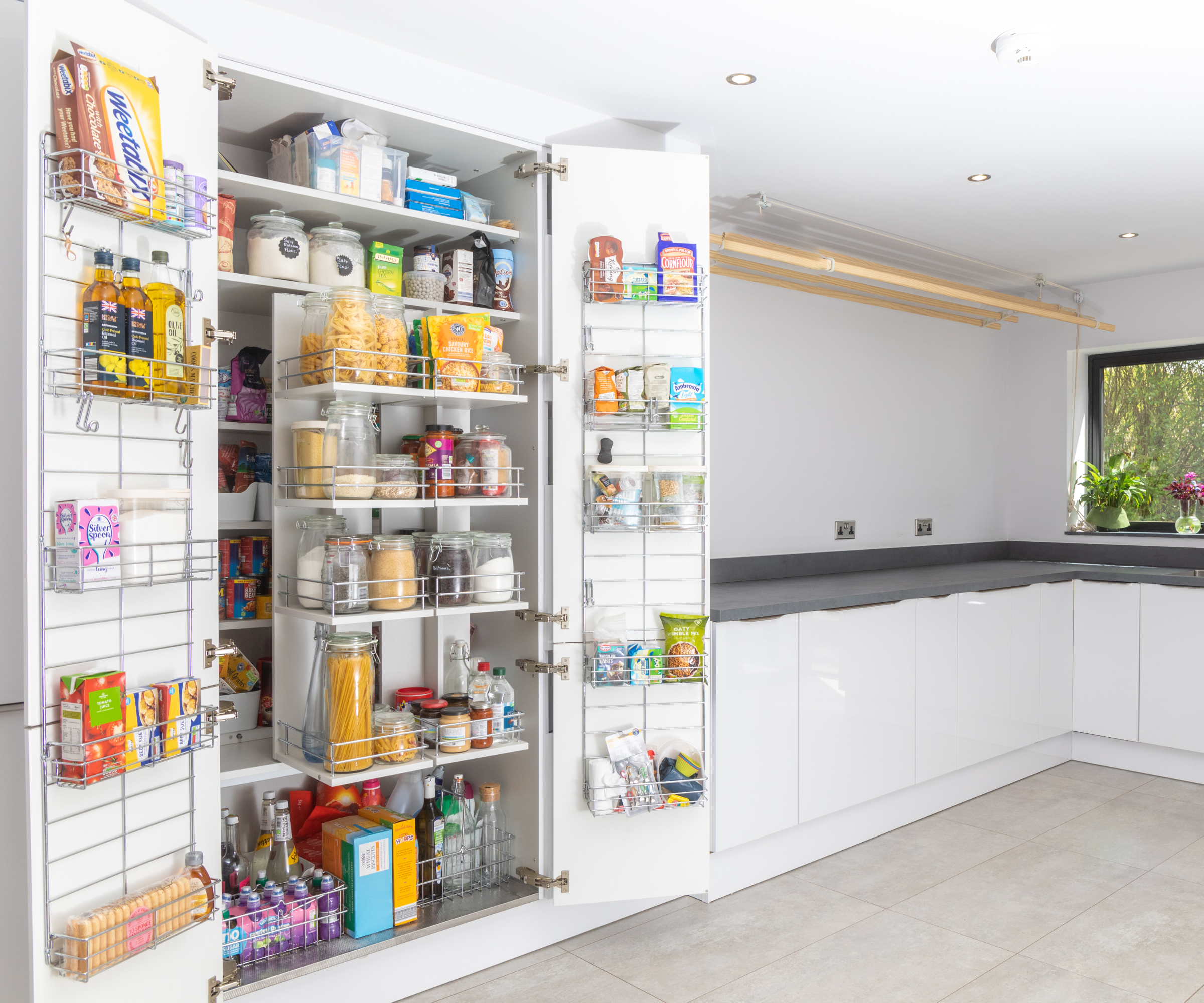 large white pantry cupboard with shelving and racks on doors