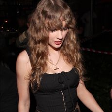 Taylor Swift in Australia wearing a black top and gold necklace