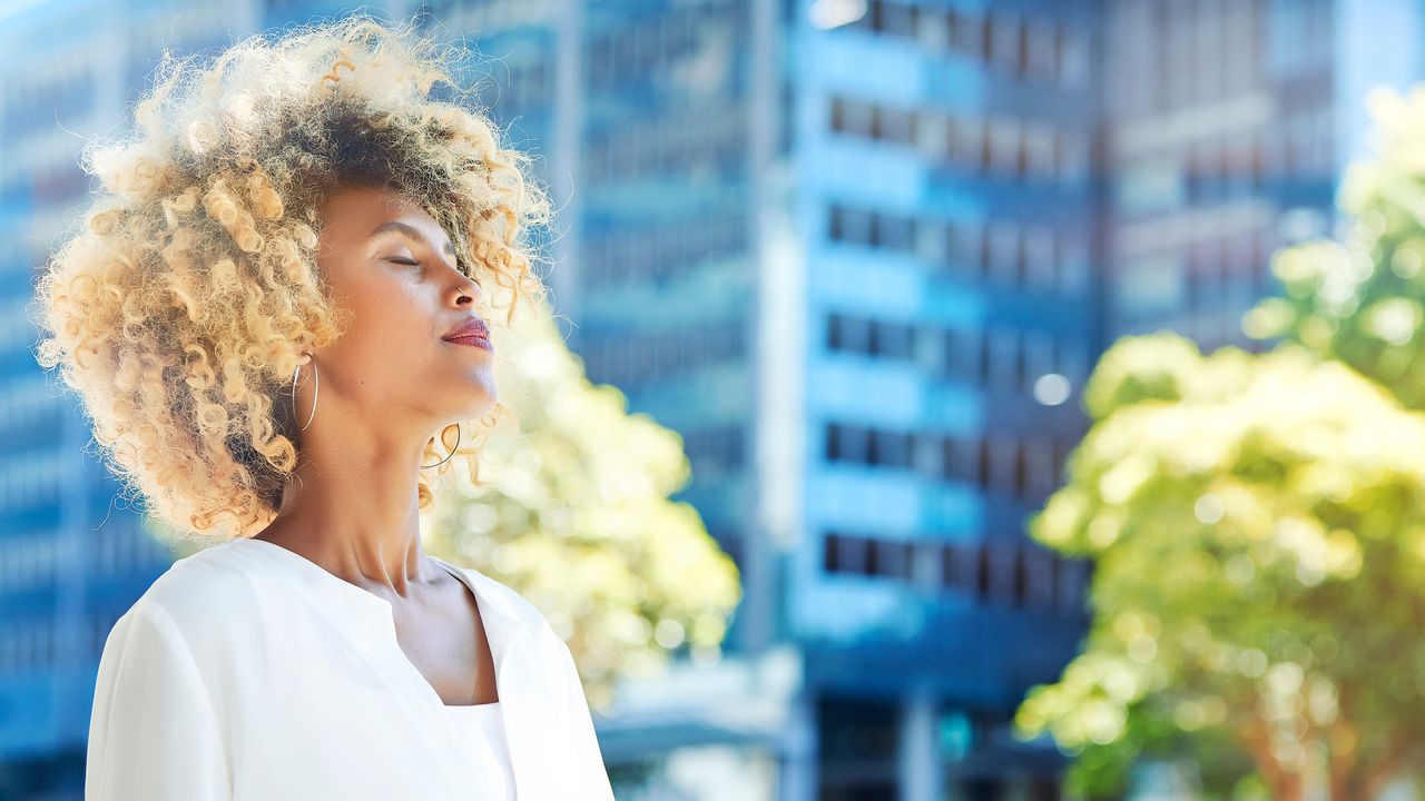 Woman completing a breathing exercise on a sunny day