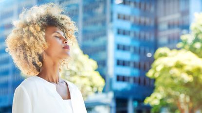 Woman completing a breathing exercise on a sunny day