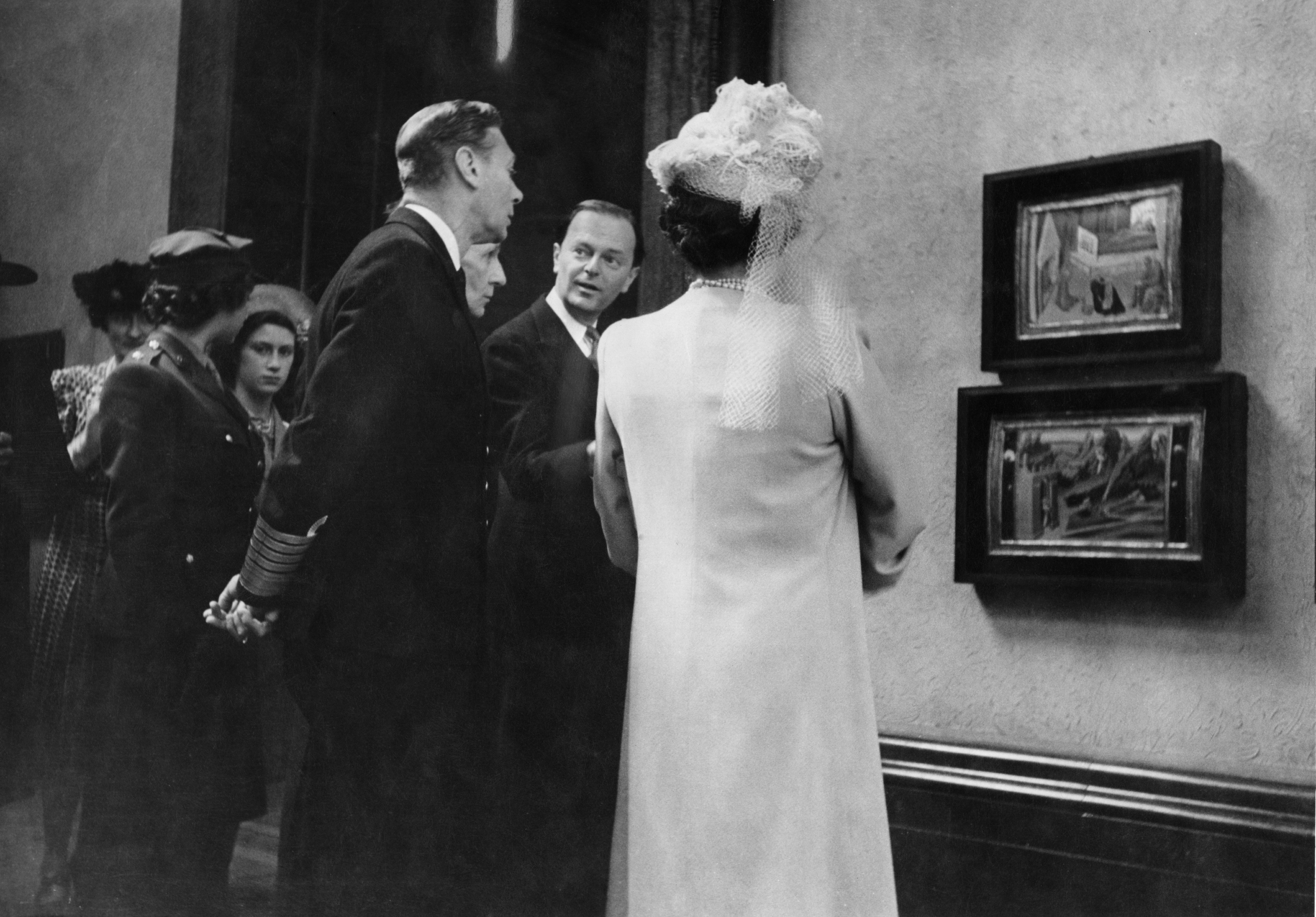 King George VI, The Queen Mother, Princess Elizabeth and Princess Margaret looking at artwork with Kenneth Clark