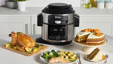 The Ninja Foodi Max 15-in-1 SmartLid Multi-Cooker omringet av en rekke forskjellige middager og desserter