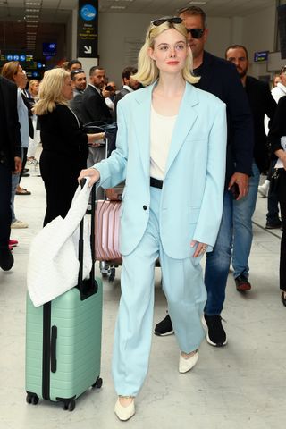 Elle Fanning wearing a blue Bottega Veneta suit at the airport in Nice, France May 2024