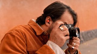 Photographer wearing a jacket with Google PIxel Buds Pro in his right ear