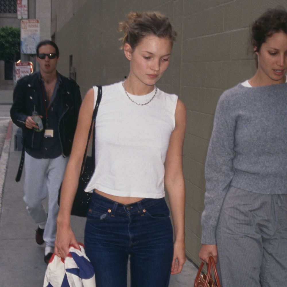 Kate Moss wears cigarette jeans with a white sleeveless top.