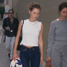 Kate Moss wears cigarette jeans with a white sleeveless top.