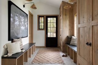 Hallway with wooden built-in storage and herringbone brick floor